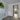 Modern interior with gray wood-look flooring, white walls, white door, and black-framed glass hinged door