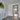 Modern interior with white walls, glass hinged door with black frame, wooden floor, and lime artwork