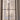 Double-hinged glass door with black metal frame in a white room under renovation