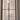 Double-hinged glass door with black metal frame in a white room under renovation