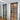 Modern interior room with black-framed frosted glass hinged door and wooden floor