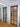 Modern interior room with black-framed frosted glass hinged door and wooden floor
