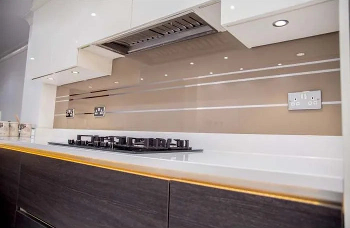 Modern kitchen with sleek glass backsplash and integrated lighting for luxury residential design