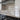 Modern kitchen with frosted glass backsplash featuring horizontal stripes, sleek black countertop and stainless steel hood