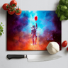 Colorful space-themed chopping board with an astronaut holding a red balloon, surrounded by fresh ingredients