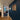 Interior hallway with wood flooring, navy blue accent wall, photo collage, and black framed glass hinged door