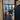 Black framed glass hinged door with grid panes opening to a bright room with a table and toys