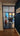 Black framed glass hinged door with grid panes opening to a bright room with a table and toys