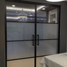 Double hinged black framed glass doors with frosted middle panels in modern interior