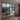 modern black-framed double glass door with side panels dividing living room and dining area