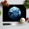 Kitchen knife and vegetables on Earth print chopping board with tomato, garlic, and herbs