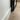 Close-up of a black metal door frame near a white wall with light wood flooring and cardboard box in background