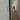 Narrow hallway with wooden floor, white walls, coat on rack, and front door in background