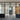 Modern interior with black metal framed glass double doors and side panels, wooden door and brick wall