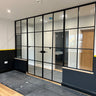 Modern black metal framed double doors with glass panels and two side panels in a contemporary room