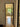 Bright room with herringbone wood floor, glass black-framed door open, window with plants and photo frame