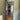 Interior hallway with open black-framed glass door, wooden herringbone floor, green walls