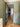Interior hallway with open black-framed glass door, wooden herringbone floor, green walls