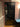 Modern black framed glass door in interior hallway with wooden floor and mauve walls