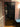 Modern black framed glass door in interior hallway with wooden floor and mauve walls