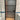 Modern bathroom door with frosted glass panels and black frame against white tiled walls