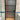 Modern bathroom door with frosted glass panels and black frame against white tiled walls