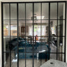 Modern black metal double glass doors with side panels separating living and sitting areas