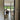 Open black-framed glass door leading to living room with brown armchair and dog by large sliding garden doors