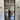 Black framed glass interior door showing a modern home with wooden furniture and outdoor garden view