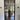 Black framed glass interior door showing a modern home with wooden furniture and outdoor garden view
