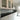 Modern kitchen with sleek white cabinets, black countertop, and grey glass splashback