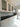 Modern kitchen with sleek white cabinets, black countertop, and grey glass splashback
