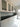 Modern kitchen with sleek white cabinets, black countertop, and grey glass splashback
