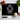 Black chopping board with orange-eyed panther face design, kitchen knife, garlic, tomatoes, and basil on white surface