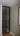 Modern black-framed glass hinged door in interior hallway with green wall and radiator