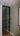 Modern black-framed glass hinged door in interior hallway with green wall and radiator