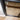 close-up of black hinged glass door frame on wooden parquet floor near white wall corner