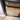 close-up of black hinged glass door frame on wooden parquet floor near white wall corner