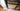 close-up of black hinged glass door frame on wooden parquet floor near white wall corner