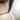 Close-up of black framed hinged glass door on light wood parquet floor against white wall