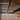 Hinged glass door with black metal frame and handle inside a beige room with ceiling smoke detectors