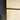 Close-up of hinged frosted glass door framed in black metal, adjacent to blue doorframe and tiled floor