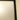 Close-up of a white hinged door with a black frame and beige wall corner in a home interior