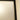 Close-up of a white hinged door with a black frame and beige wall corner in a home interior