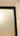 Close-up of a white hinged door with a black frame and beige wall corner in a home interior
