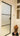 Frosted glass hinged door with black frame in a white wall hallway, stained glass panels, shoes on floor