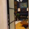 Modern interior with frosted glass hinged door, blue wall, yellow rug, wooden coffee table, and chandelier