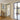 Open black framed glass hinged door in modern interior with beige walls and wooden floor
