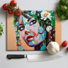 Colorful painted woman portrait with flowers, kitchen knife, garlic, tomatoes, and basil on white surface