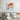 Colorful corgi dog painting on bedroom wall above wooden bed with gray linens